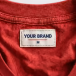Close-up of the blank t-shirt inside back neck with woven YOUR BRAND label and collar stitching