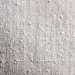 Close-up of the white poly-cotton poplin plain weave with interlaced warp and weft threads and natural fibre slubs