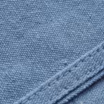 Close-up of the ceil blue poly-cotton twill weave of the healthcare uniforms, showing the diagonal rib, individual yarns, natural fibres and a felled seam
