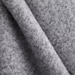 Close-up of grey marl brushed fleece showing the dense looped pile and the heathered fibre mix across a soft diagonal fold