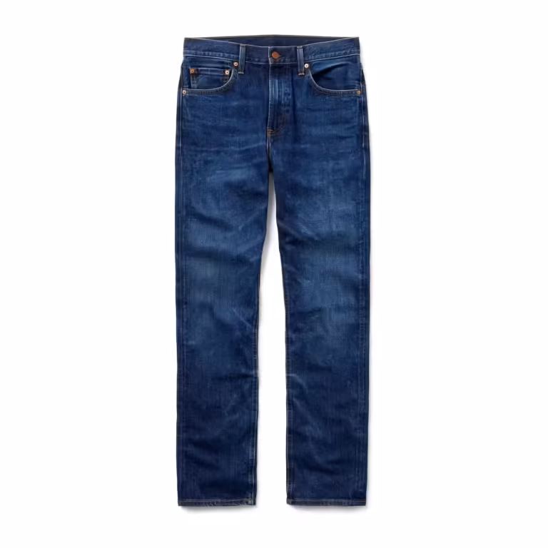 Men's jeans pants in mid indigo denim, full front view of the classic five-pocket jean with scoop front pockets, coin pocket, copper rivets, belt loops and golden-brown contrast topstitching