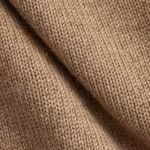 Close-up of the camel knit showing stocking stitch columns, individual yarn fibres and a soft fold in the knitted fabric