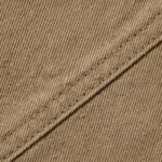 Close-up of the khaki cotton twill cloth of the work shirt showing the diagonal weave ribs, individual yarns and a stitched felled seam