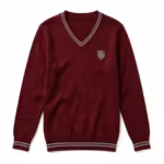 Knitted school sweater in burgundy with a V-neck band carrying two light grey stripes, an embroidered shield crest on the chest and striped ribbed cuffs and hem, full front view