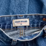 Close-up of the slim fit jeans inside back waistband with woven YOUR BRAND label and waistband stitching