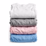 Folded stack of knit undergarments seen from the back in white, grey marl, soft pink and sky blue - the folded backs of a cotton rib vest over folded briefs and a trunk, matte jersey and rib knit