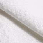 Close-up of the white poly-cotton plain weave of the tapered apron, showing the warp and weft yarn structure, natural fibres and a soft fold