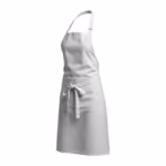 White tapered bib apron in poly-cotton, three-quarter angle view with adjustable neck strap, wide divided front pocket and long waist ties knotted in a bow at the front
