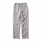 Chef trousers in a small light grey and white woven check, full front view with part-elastic drawstring waist, slanted side pockets and a loose straight leg