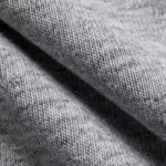 Close-up of the grey marl cotton single jersey knit of the corporate t-shirts, showing the yarn loops, heathered fibres and a soft fold