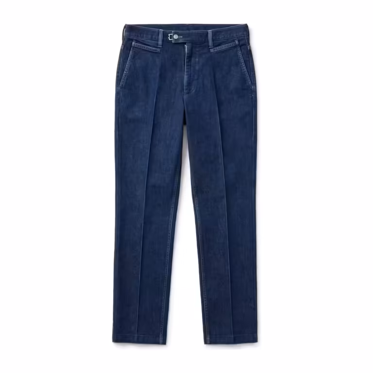Men's denim trousers in indigo denim, full front view with flat front, slanted pockets, tailored waistband with hook-and-bar closure and pressed leg creases