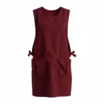 Burgundy work tabard with pockets in poly-cotton, full front view with bound scoop neck, deep armholes, two divided front patch pockets and side ties tied in bows