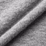 Close-up of the grey marl cotton single jersey showing the fine knit stitch loops, heathered yarn fibres and a soft fold