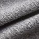 Close-up of grey marl smooth interlock knit across a soft fold, showing the fine knit loops and the heathered fibre mix